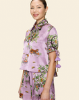 Woman wearing a floral purple outfit on a light background
