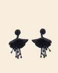 Pair of black beaded floral earrings on a beige background
