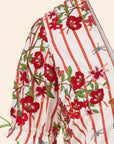 Floral and striped fabric with red flowers and green leaves on a white background