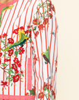 Close-up of a colorful floral and bird patterned fabric with red stripes.