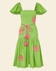 Green dress with pink floral accents on a beige background