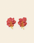 Pair of red floral earrings on a beige background