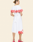 Woman wearing a white skirt and cape with pink floral details