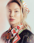 Woman wearing a patterned scarf with a tiger design on a plain background