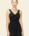 Woman wearing a black cotton-lycra bra top with a V-neckline, and a black skirt