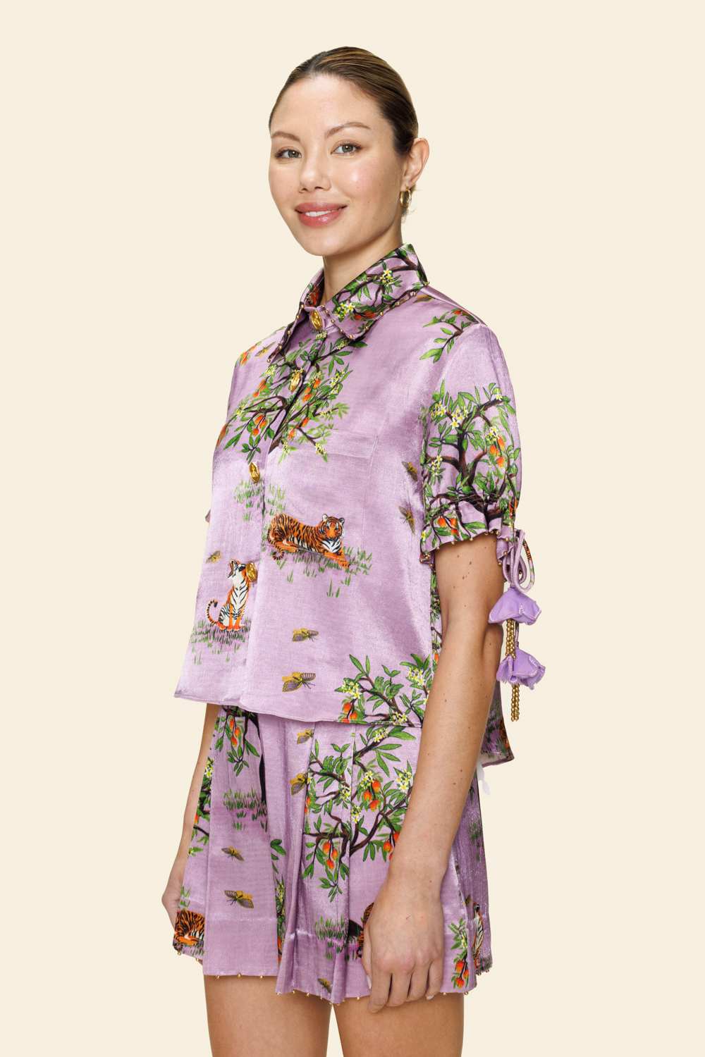 Woman wearing a floral purple outfit on a light background