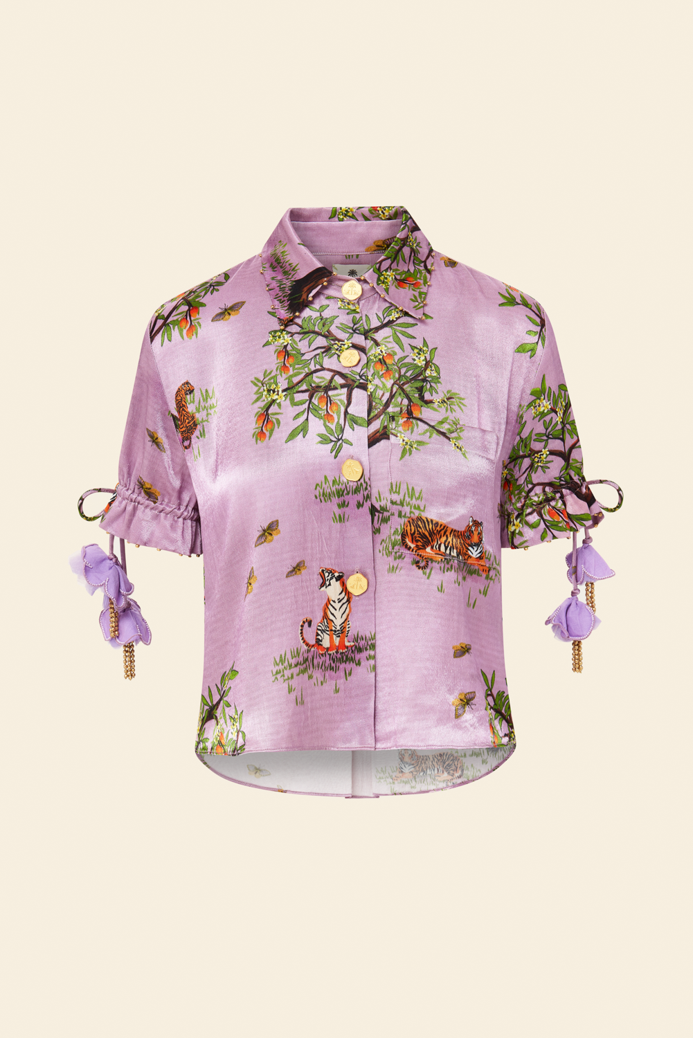 A purple blouse with floral print and embellishments, including beaded drawcord sleeves and a brass beaded collar.