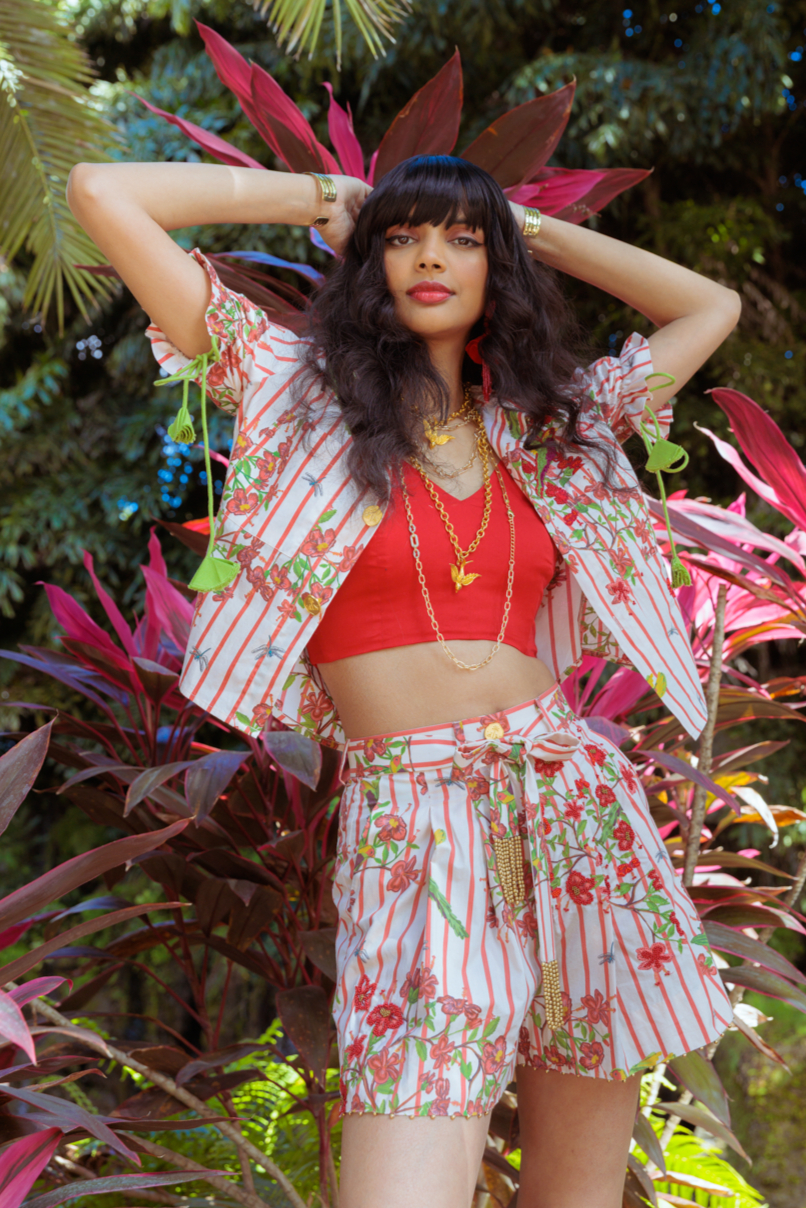 Woman in a floral outfit standing among tropical plants