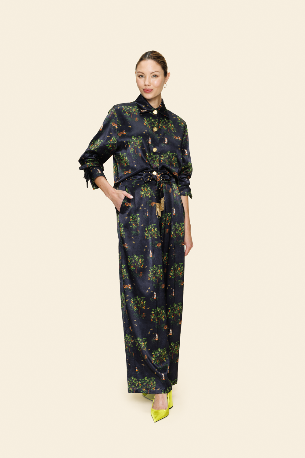 Woman wearing a floral patterned outfit on a plain background