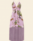 A pink midi dress with a floral print, an empire waist, adjustable rope straps, and a high-low hem with fringe trim.