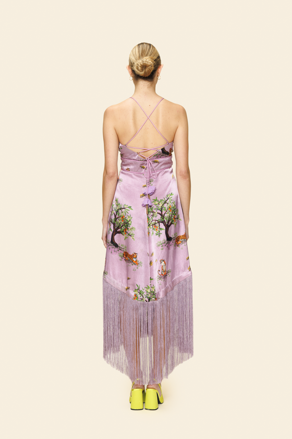 Woman wearing a purple dress with tree pattern on a plain background