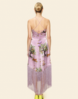 Woman wearing a purple dress with tree pattern on a plain background