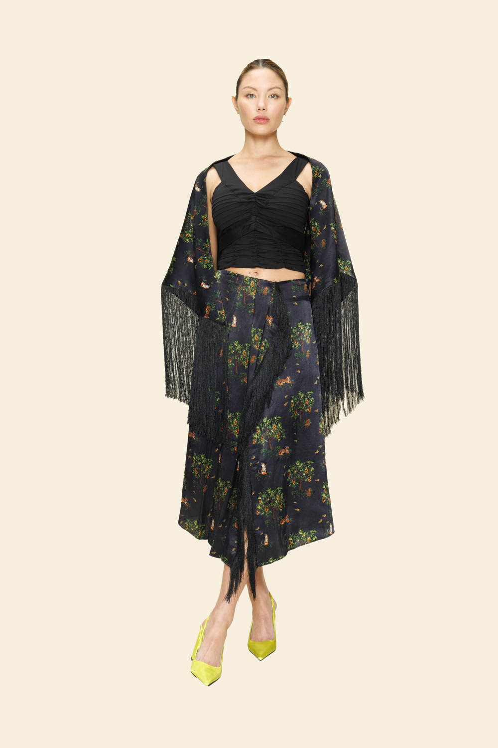 Woman wearing a black outfit with a floral pattern on a plain background