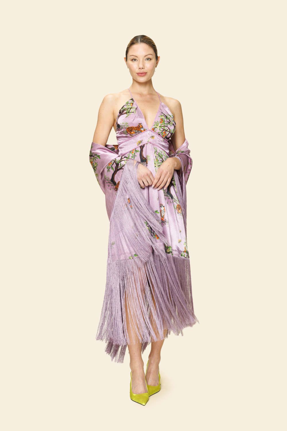 Woman wearing a purple floral dress on a plain background