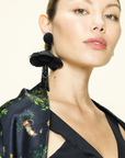 Closeup of Woman wearing large, black, beaded, floral earrings 