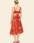 Woman wearing a red skirt with a floral pattern on a beige background
