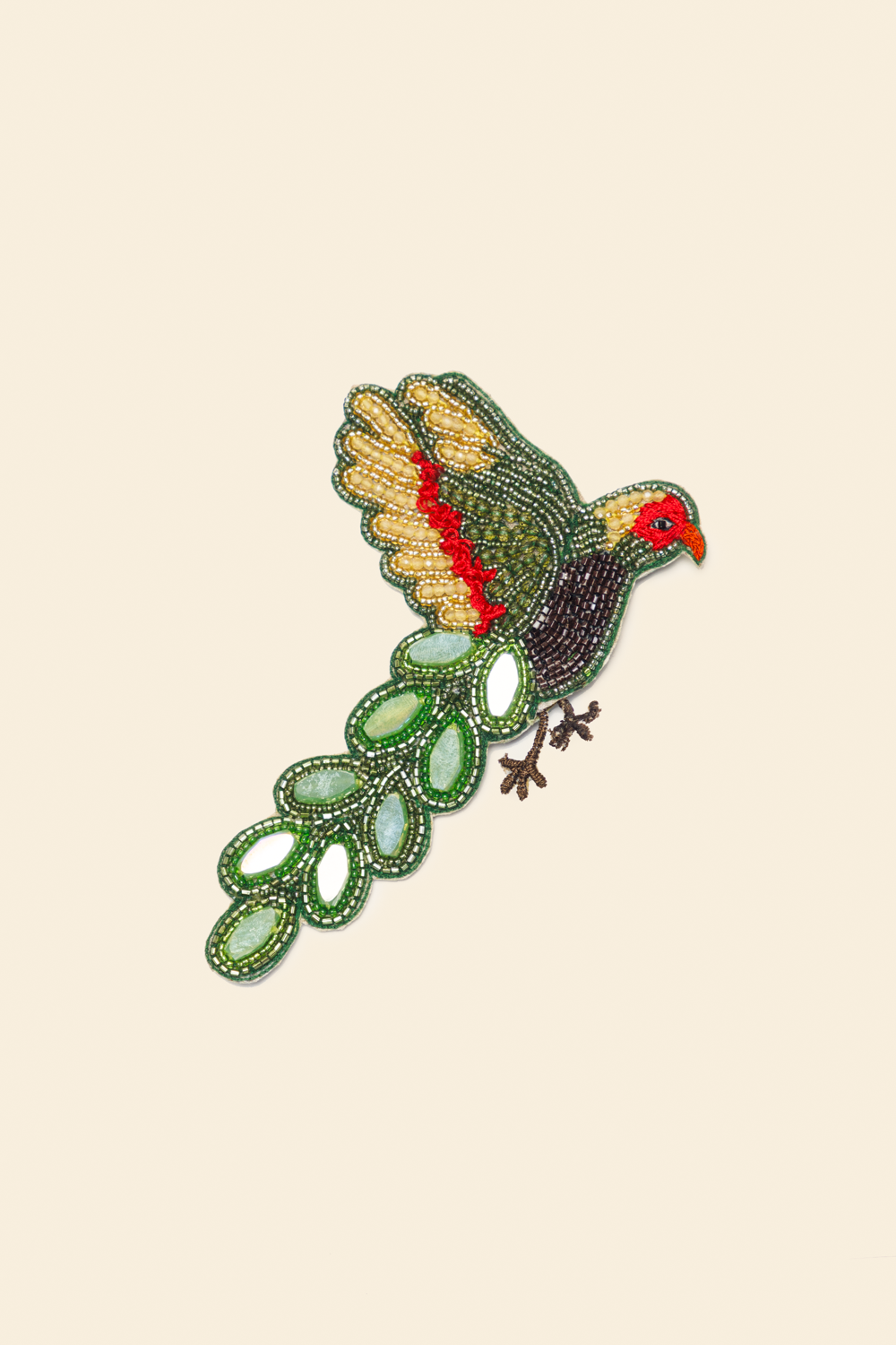 Embroidered brooch with parakeet design on a beige background