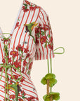 Red and white striped shirt with floral and parrot pattern on a beige background