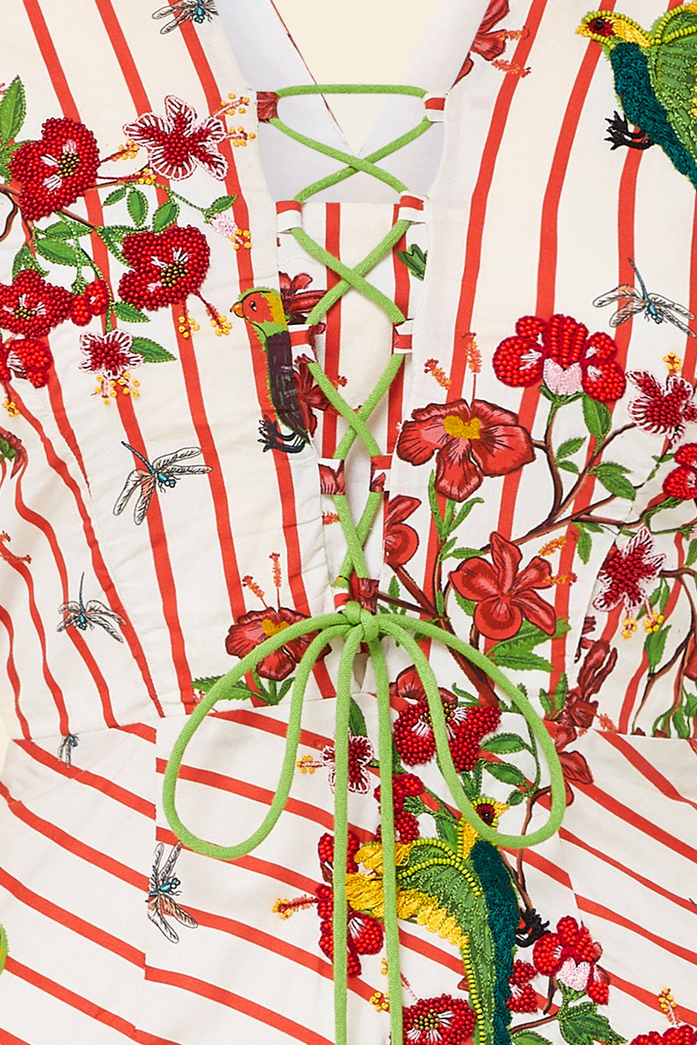 Decorative coat rack with green metal hooks against a colorful floral and striped background