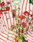 Decorative coat rack with green metal hooks against a colorful floral and striped background