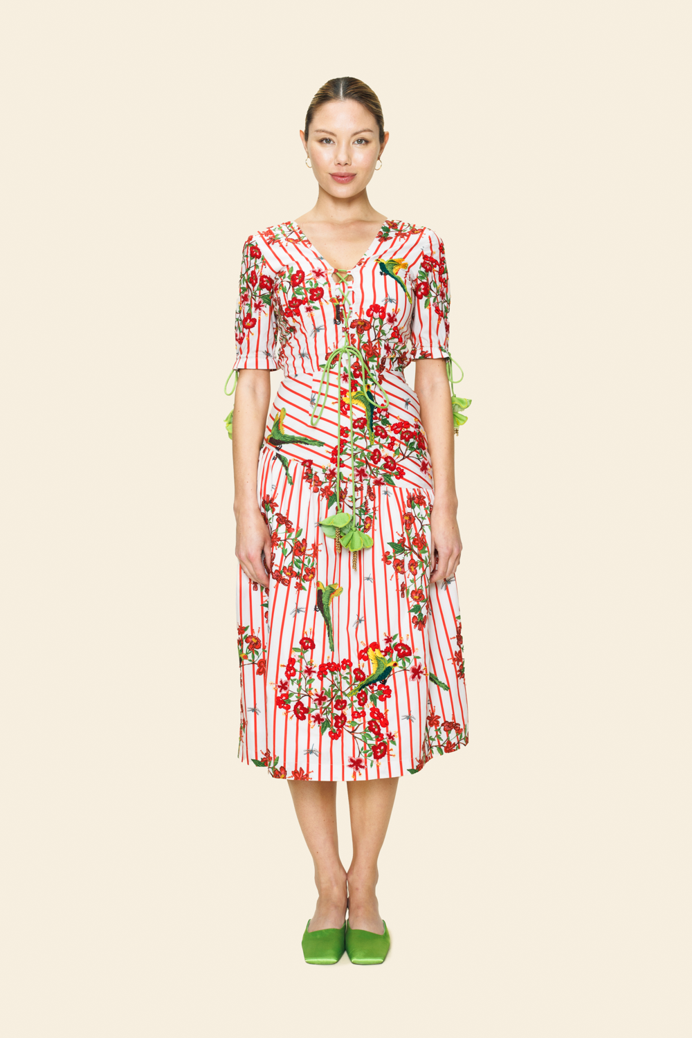 Woman wearing a red and white floral dress on a beige background