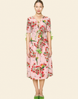 Woman wearing a red and white floral dress on a beige background