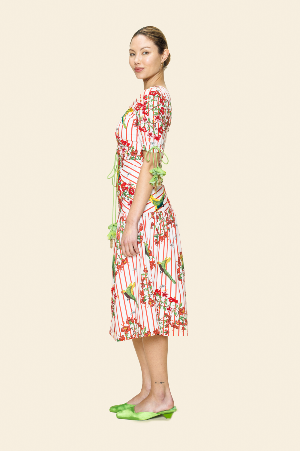 Woman wearing a red and white floral dress on a beige background