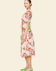 Woman wearing a red and white floral dress on a beige background