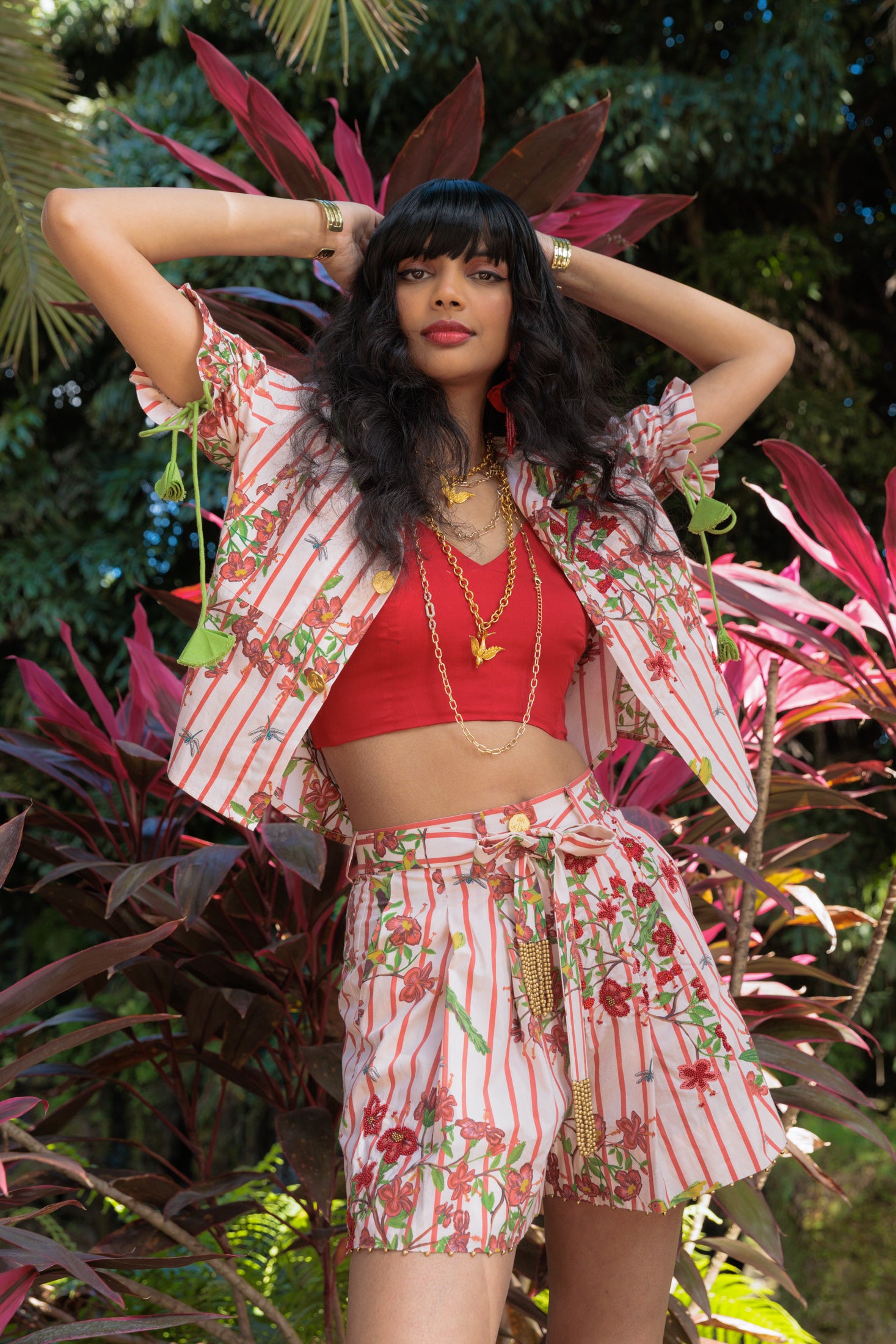 Woman in a red striped top and shorts standing among plants
