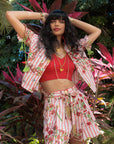 Woman in a red striped top and shorts standing among plants