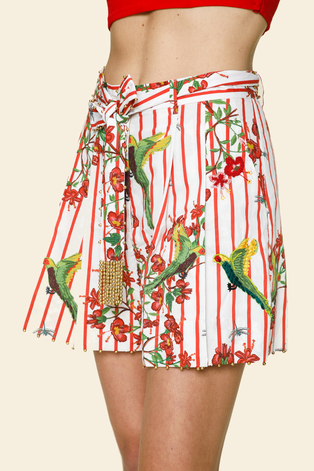 Shorts with parrot and floral pattern on a beige background