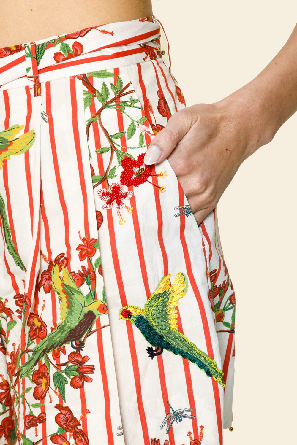 Close-up of a colorful skirt with bird and floral patterns on a beige background