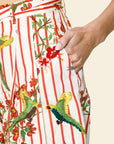 Close-up of a colorful skirt with bird and floral patterns on a beige background