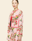 Woman wearing a red and white floral jacket with a beige background