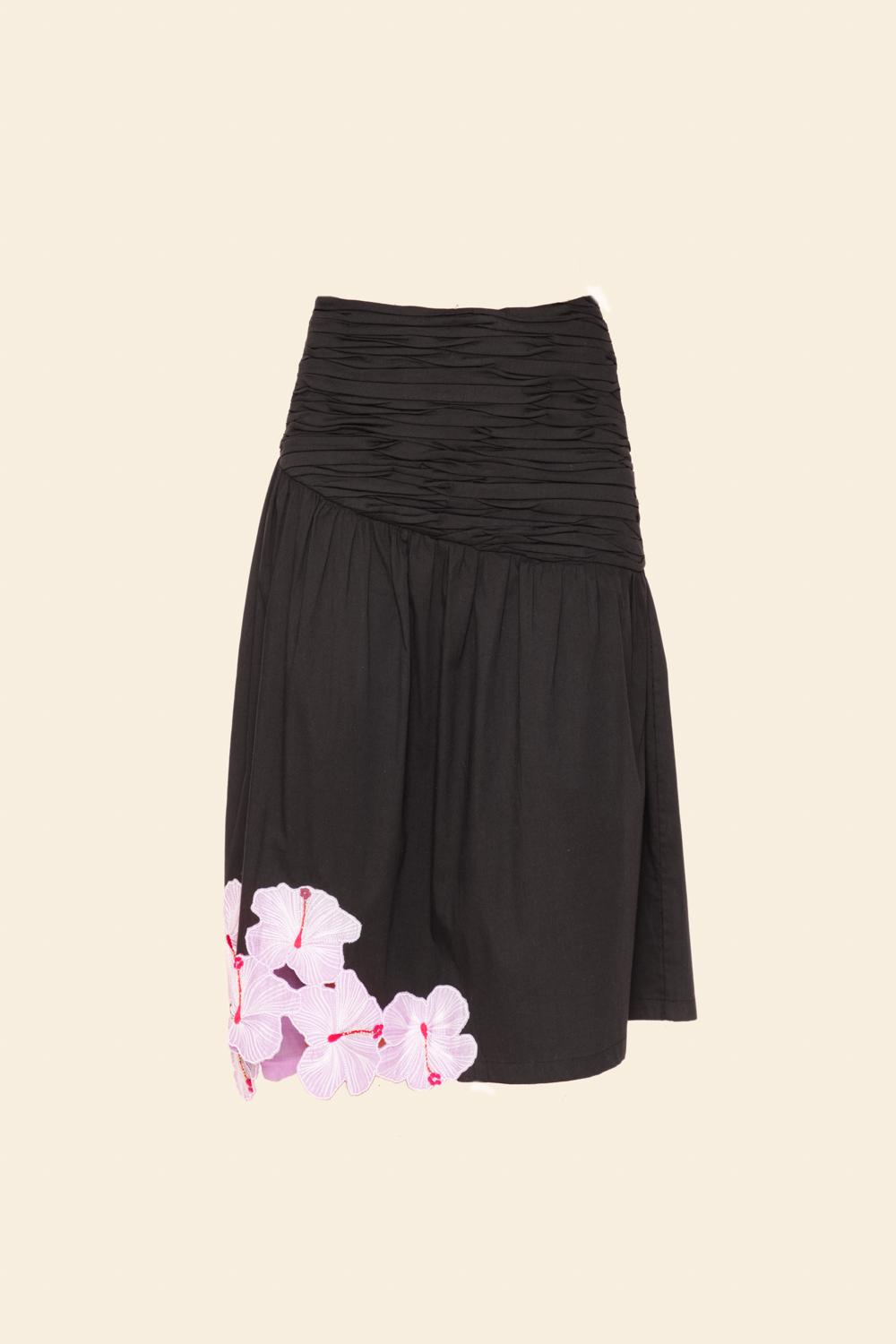 A midi skirt with floral applique on the lower right side, predominantly black in color.