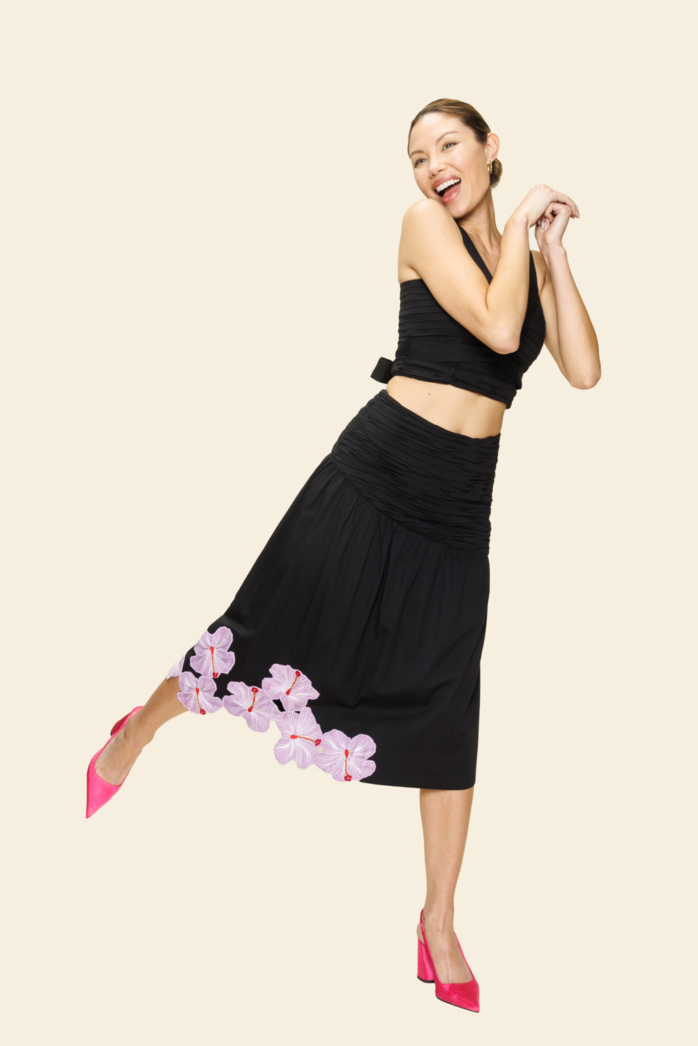 Woman in a black outfit with floral details on a beige background