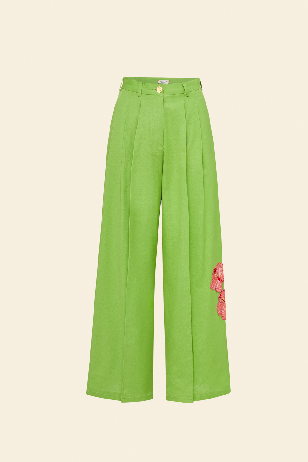 A tailored green cotton-linen trouser with a single hand-embroidered pink hibiscus on the left leg, featuring double front pleats and a fly-front closure.