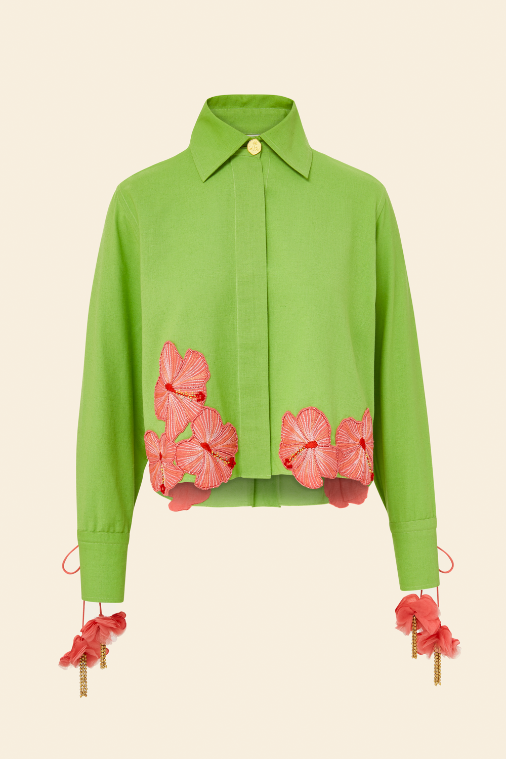 A long sleeve embroidered shirt in green with pink floral applique on the hem and cuffs, featuring drawcord cuffs.